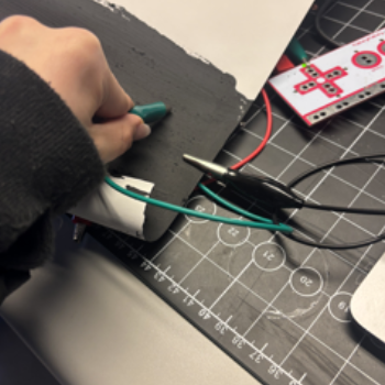 Using conductive paint, I stuck the ground wire to the paint and lightly placed the green wire on the paint, making the code flick.